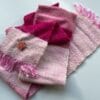 Kleine handgesponnen en handgeweven sjaal in roze en wit. Met alpaca, merinowol en sarizijde op een katoenen ketting.