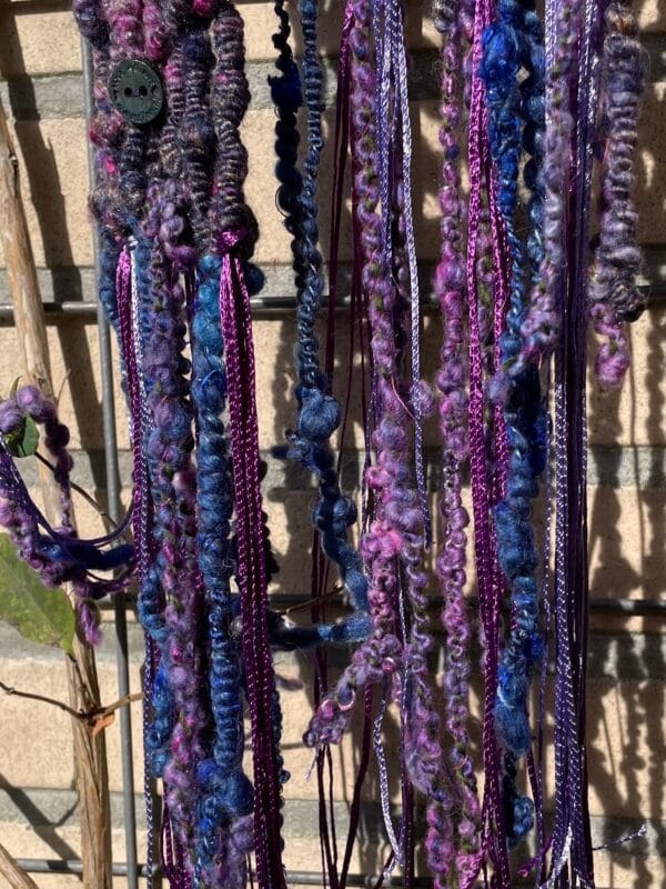 Handgesponnen en handgebreide boho sjaal. In paars en blauw met mohair lokken en kunstgaren franjes.