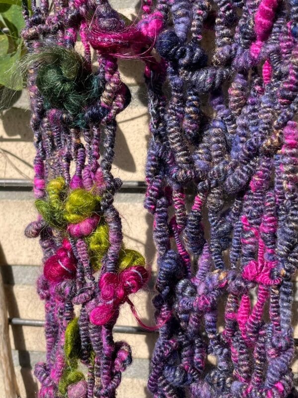 Handgesponnen en handgebreide boho sjaal. In paars en blauw met mohair lokken en kunstgaren franjes.