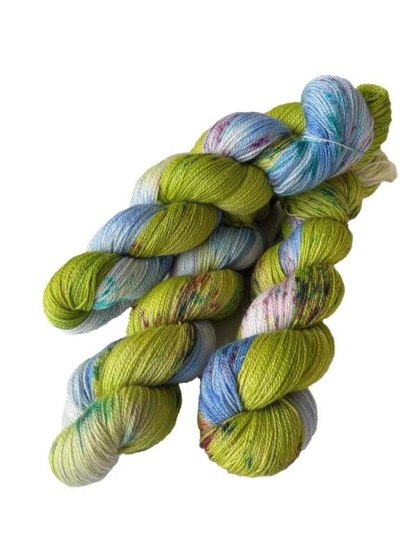 il_fullxfull.5354396435_4366.jpg Handgeverfd superwash Merino en bamboe kantgaren. Hemelsblauw en lentegroen met fluorescerende spikkels. Lente