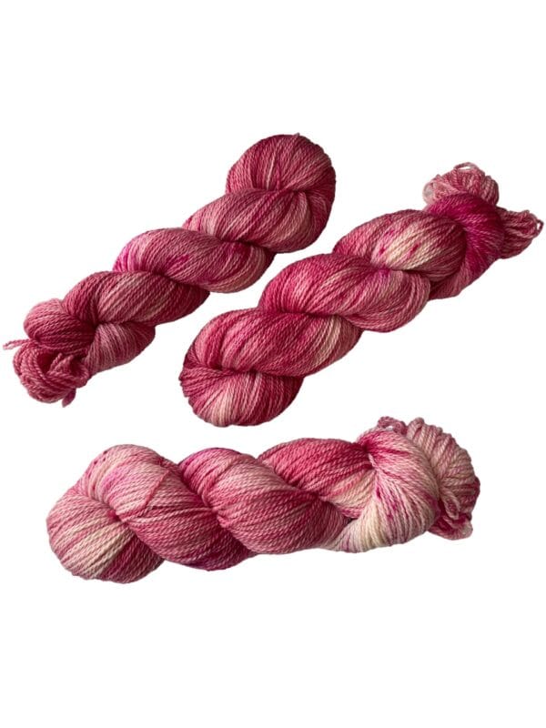 Hand dyed superwash Merino and bio nylon sock weight yarn. Warm pink and white with fluorescent speckles.