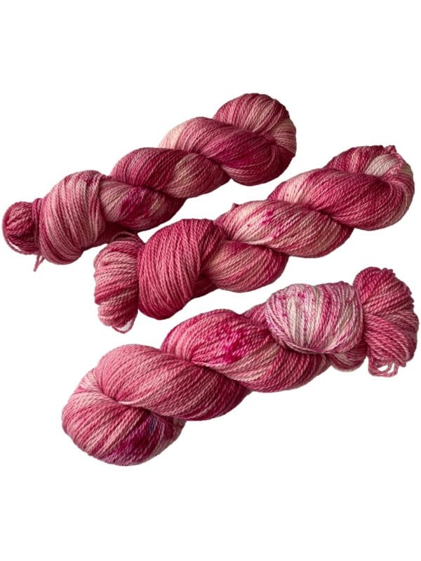 Hand dyed superwash Merino and bio nylon sock weight yarn. Warm pink and white with fluorescent speckles.