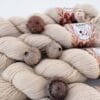 img_0338353dd104.jpg Light beige skeins of 4-ply yarn with S7oRS Atelier labels and four brown oak galls.