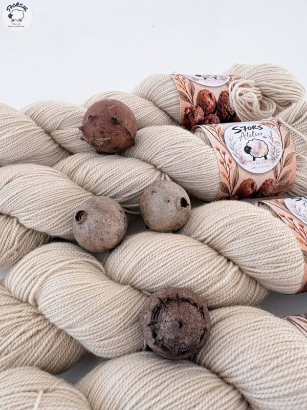 img_0338353dd104.jpg Light beige skeins of 4-ply yarn with S7oRS Atelier labels and four brown oak galls.