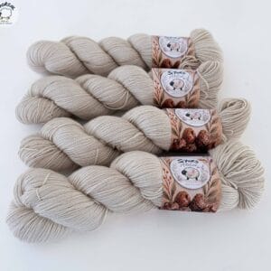 Vier licht beige strengen 4-ply garen met S7oRS Atelier-labels op een witte ondergrond.