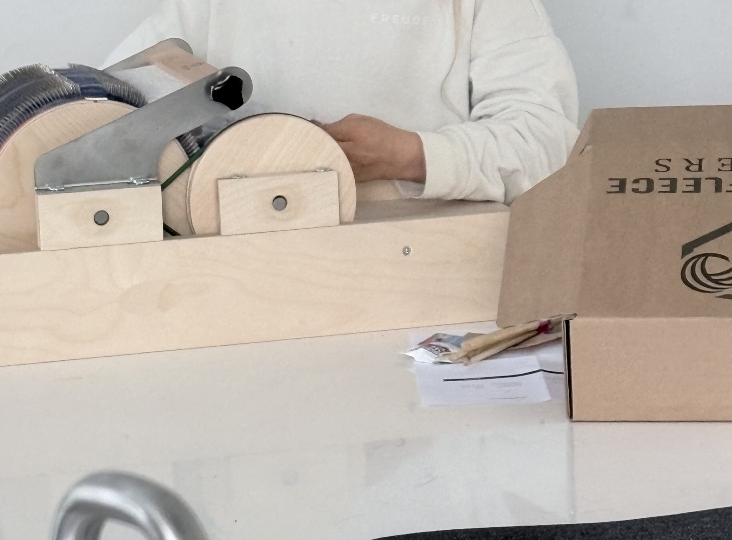 Handen bij de Golden Fleece-kaardmolen in het atelier.